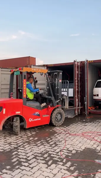 Forklift at work by the container