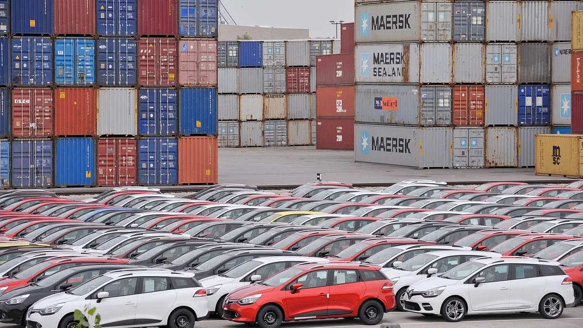 Vehicles beside shipping containers